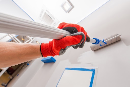 Interior commercial painting using a telescoping painting brush for high walls